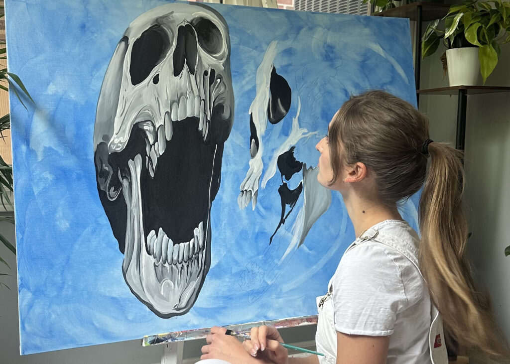 Artist Julia Brevetti working on a piece from her "Skull Collection"